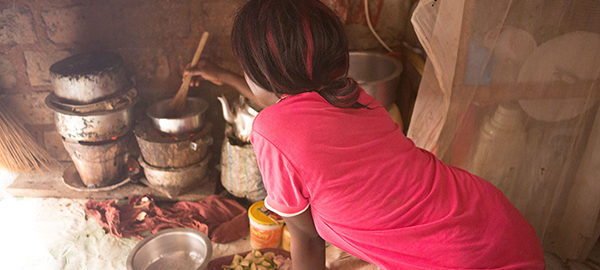 Cooking inside on a charcoal stove. Slums, Uganda